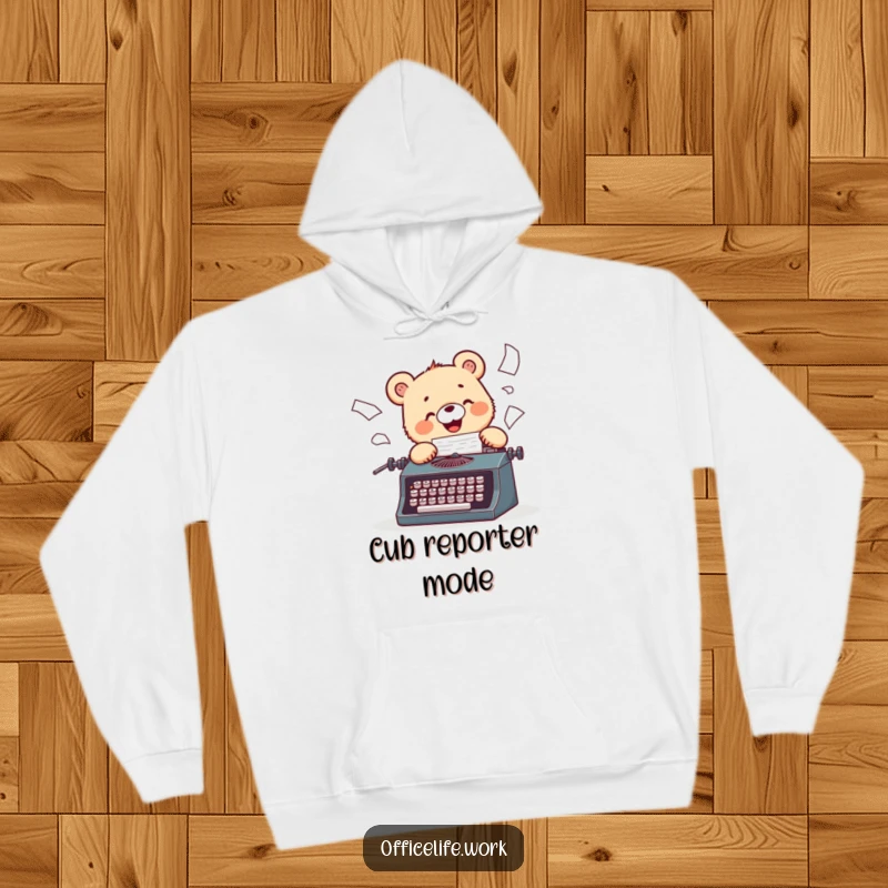 Funny hoodie depicting a cheerful bear cub intensely typing on a vintage typewriter, papers scattering wildly.